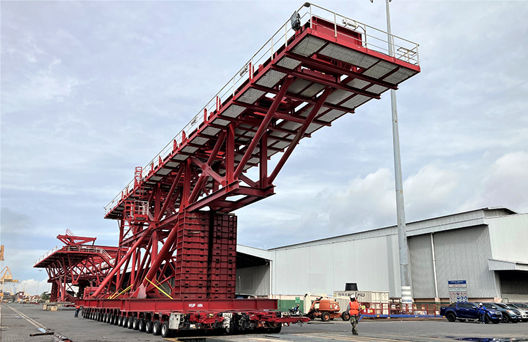 Marine survey personnel monitoring the transport and loading of offshore components.