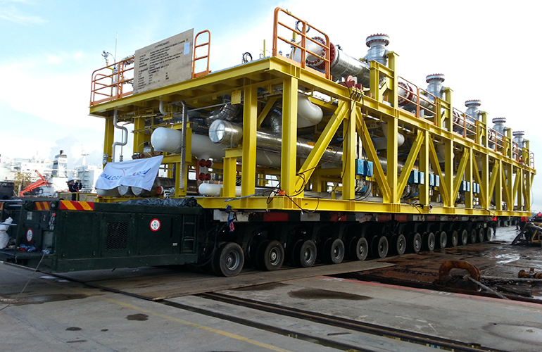 Detailed marine survey for a large yellow offshore platform structure at a shipyard.