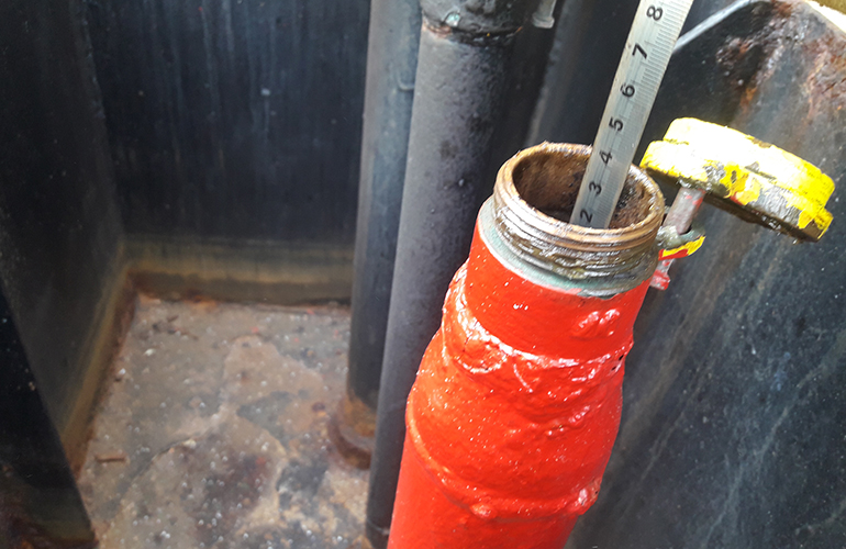 Cargo survey checking pressure gauge readings during cargo transfer process.