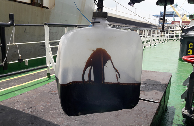 Marine surveyor conducting cargo survey inspection inside storage tank before cargo loading.