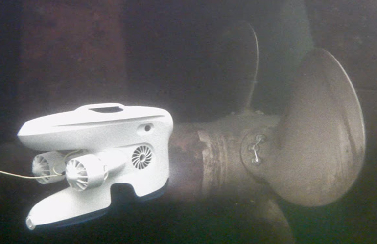 Underwater drone inspecting ship propeller during hull inspection