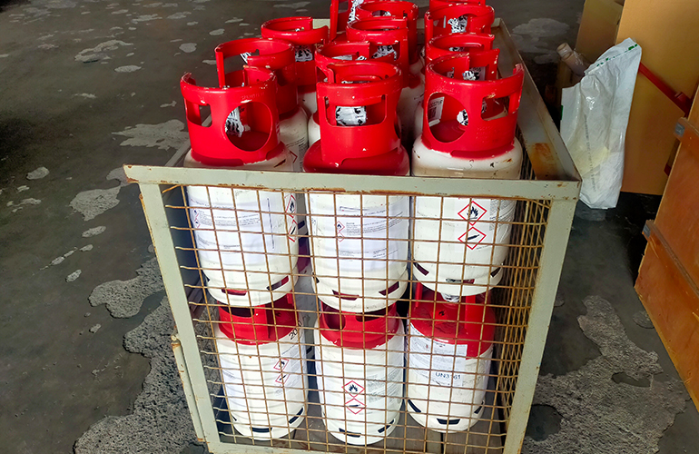 Specialized gas cylinders being prepared for secure container cargo shipping.