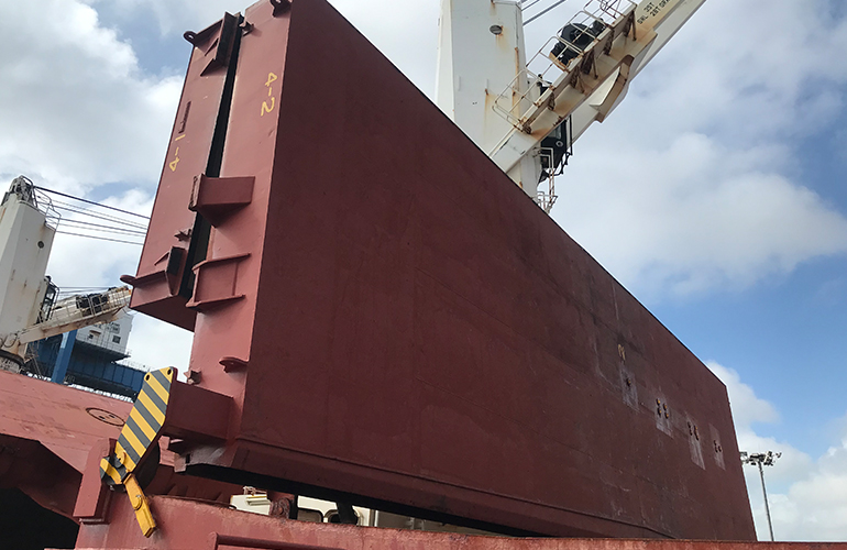 Professional inspection of a vessel hull section prior to shipment and cargo loading.