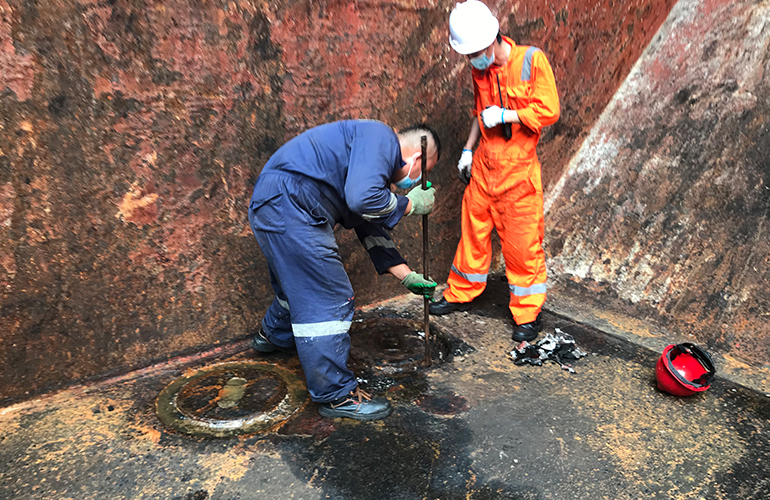 Surveyors conducting a confined space inspection for safe shipment and cargo transport.