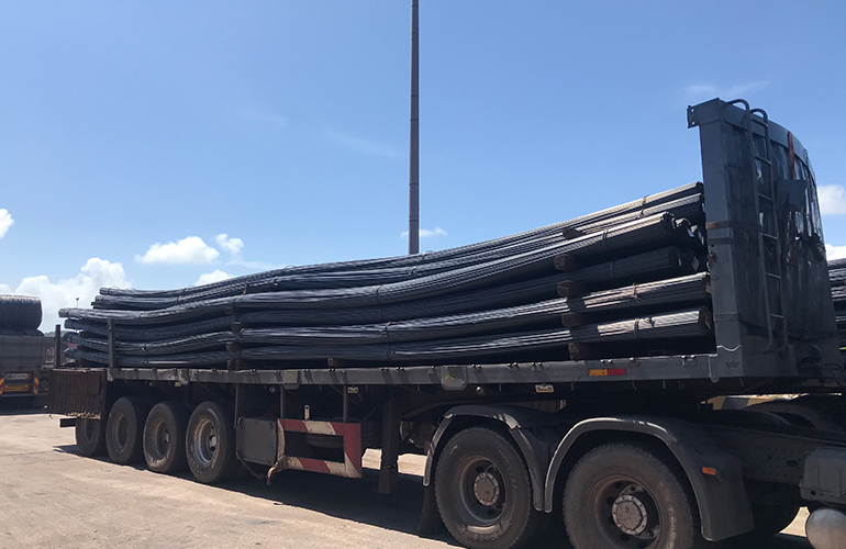 Loading oversized structural components onto a trailer for shipment and cargo delivery.