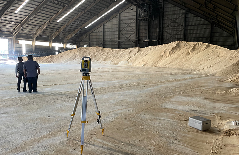Setting up surveying tools to begin an accurate stockpile inventory audit.